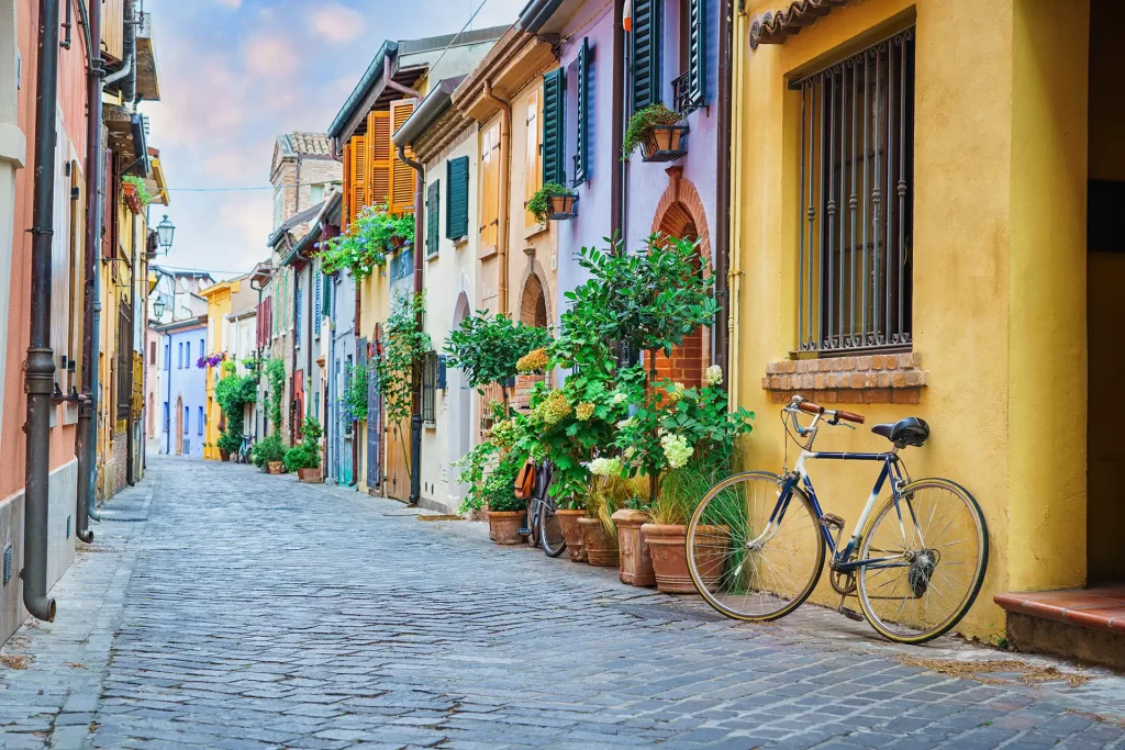 Strada colorata con case vivaci e una bicicletta appoggiata a un muro.