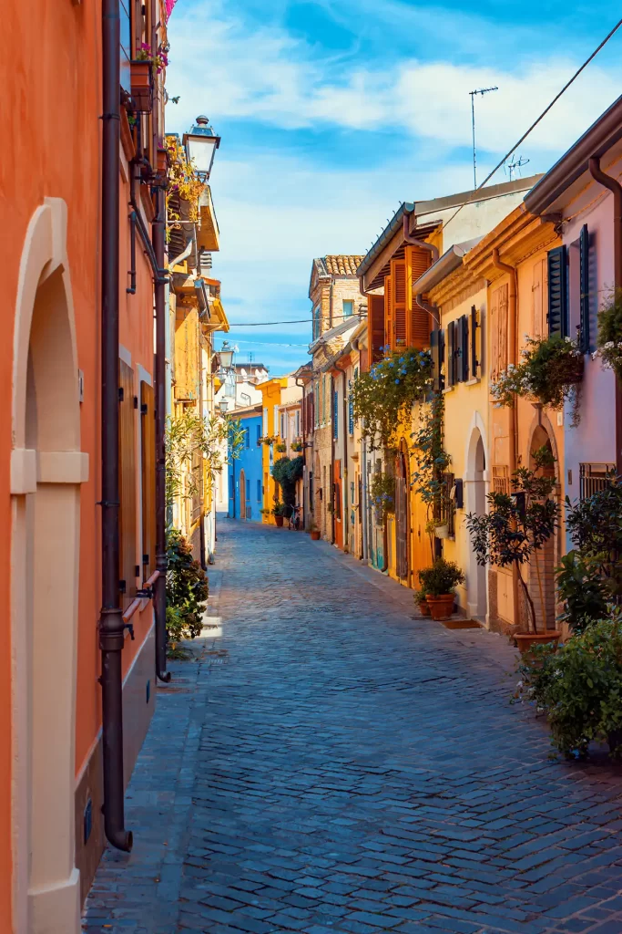 Viuzza pittoresca con edifici colorati e piante alle finestre.