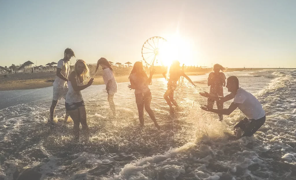 Gruppo di persone che si divertono in spiaggia al tramonto.
