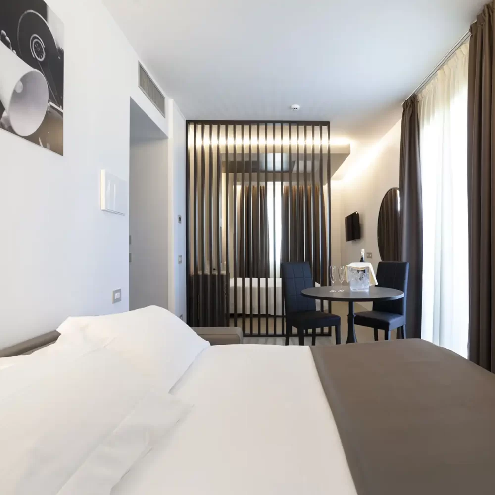 Camera d'hotel moderna con letto matrimoniale e arredi eleganti.