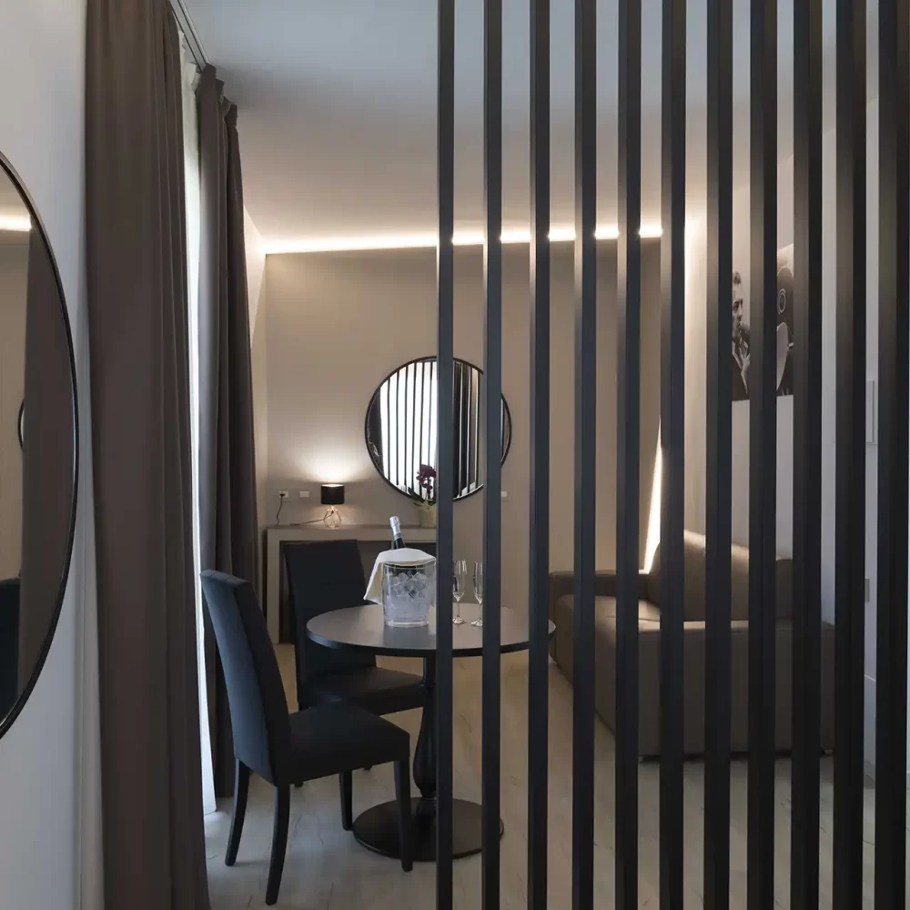 Sala moderna con specchio rotondo e divisorio a doghe verticali.