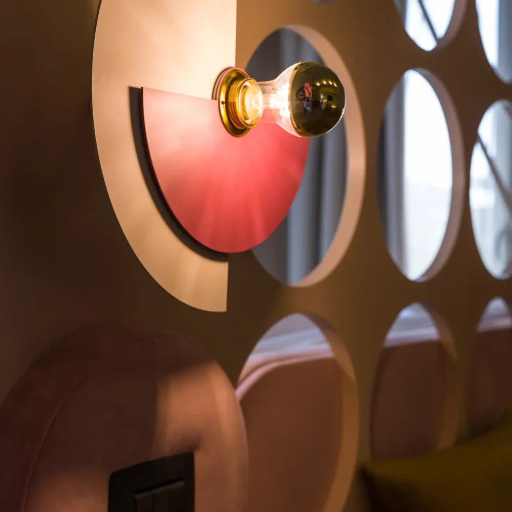 Lampada da parete moderna con pannello decorativo circolare retroilluminato.