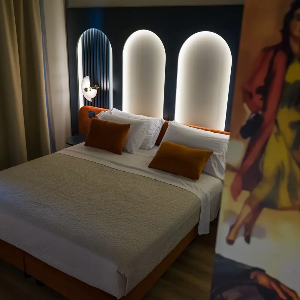 Camera d'albergo moderna e accogliente con letto matrimoniale e decorazioni artistiche.