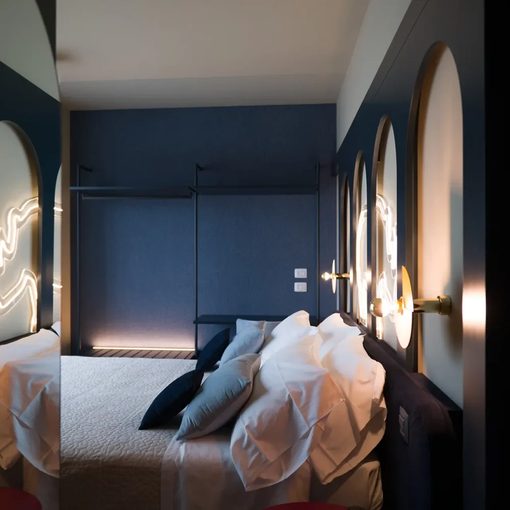 Camera da letto moderna con luci soffuse e decorazioni artistiche sulle pareti.