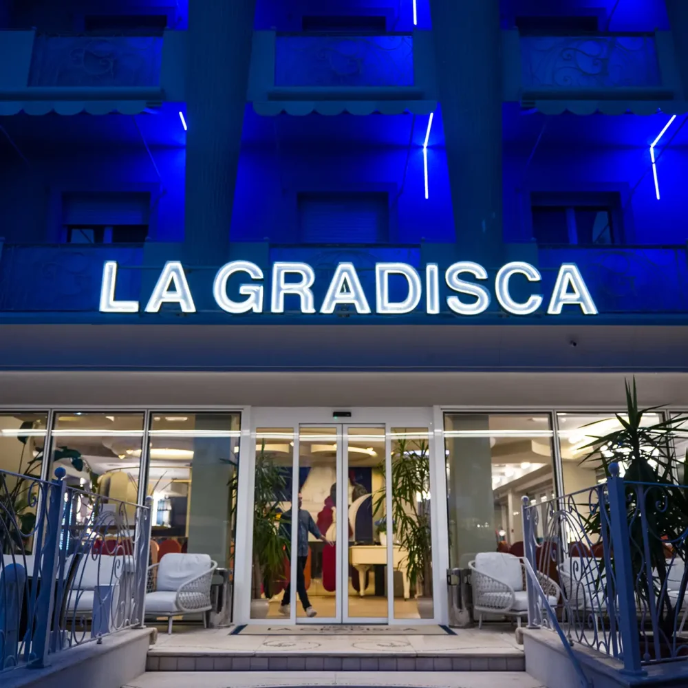 Ingresso illuminato dell'hotel "La Gradisca" con luci blu sullo sfondo.