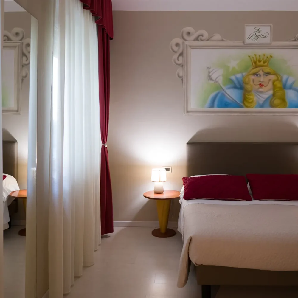 Camera da letto elegante con un grande dipinto sopra il letto matrimoniale.