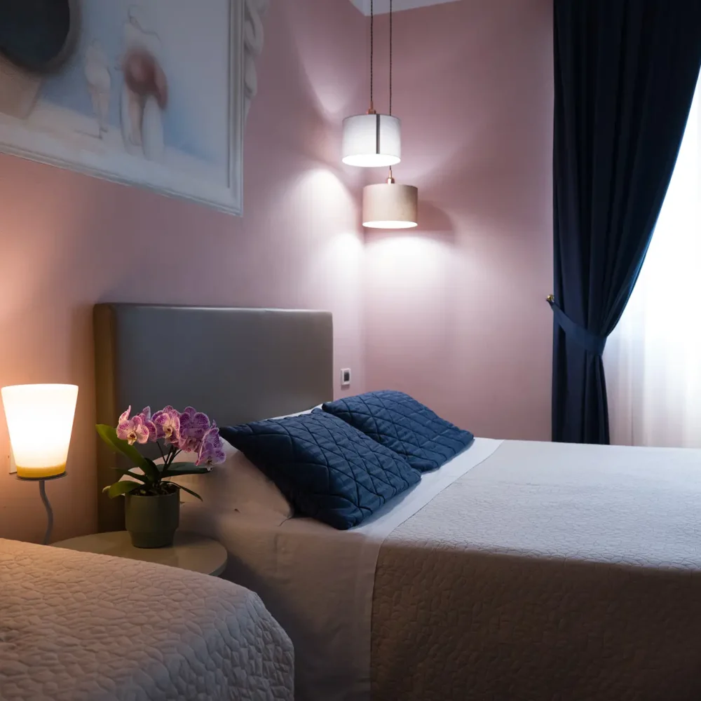 Camera da letto accogliente con letto matrimoniale, luci soffuse e tende scure.