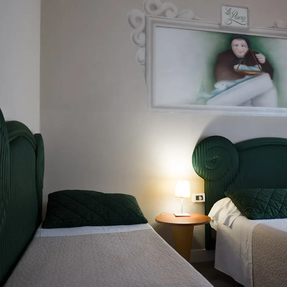 Due letti singoli in una camera decorata con una grande foto sopra la testata.